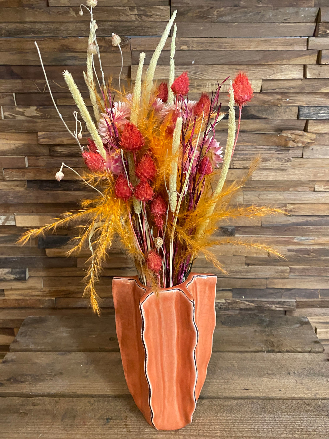 Orange vaasje met gekleurde droogbloemen m